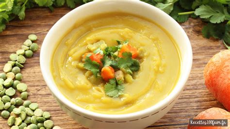 Bol de soupe onctueuse de pois cassés et carottes fumant avec des herbes fraîches