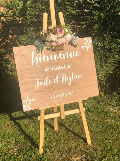 Illustration graphique d'un panneau de bienvenue fleuri posé sur un chevalet en bois dans un jardin champêtre