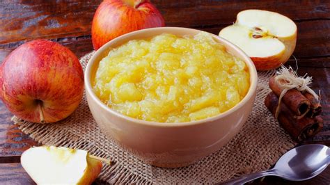 gros plan sur une compote de pomme servie dans un bol en céramique avec un filet de sirop d'érable sur le dessus