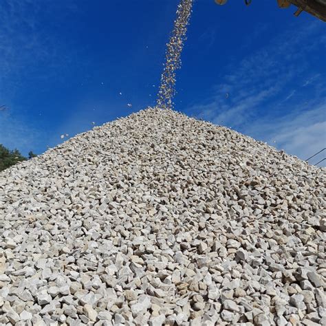 Photo de chantier montrant des sacs de gravier déversés sur des dalles stabilisatrices en cours de remplissage