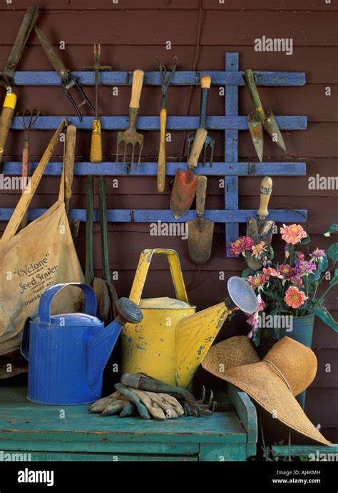 Photo d'une étagère remplie d'outils de jardinage anciens et modernes, symbolisant l'évolution du jardinage