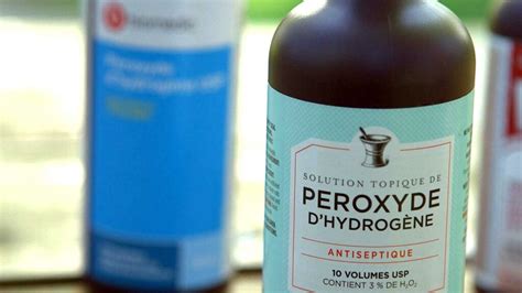 Bouteille de peroxyde d'hydrogène à côté d'un arrosoir