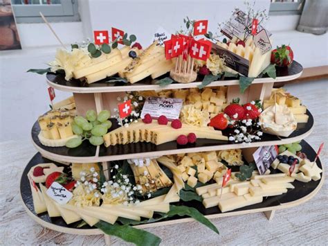 Présentation artistique d'un plateau de fromages de Savoie entouré de miel et de vin