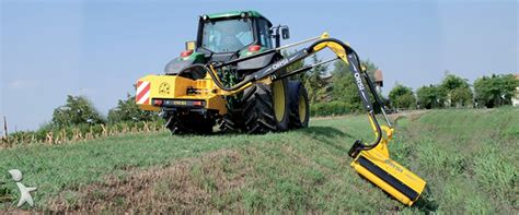 Photo d'une débroussailleuse à bras articulé en action sur un talus agricole